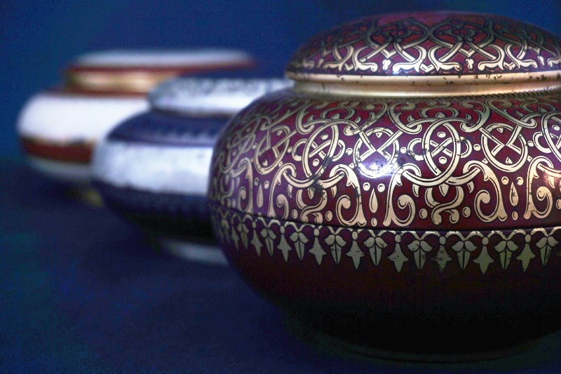 3 different style urns shown offset in a verticle line. How To Choose The Right Cremation Urn